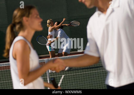 Tennisspieler Händeschütteln bei Net Stockfoto