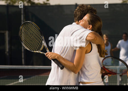 Tennisspieler umarmt am Netz Stockfoto