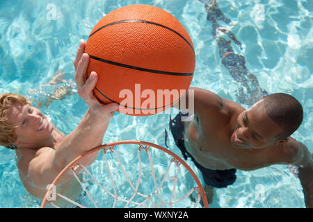 Zwei junge Männer, Wasserbasketball spielen Stockfoto