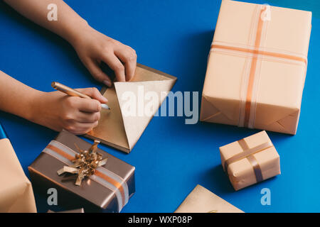 Schreiben Umschlag mit den besten Wünschen und Boxen auf blauem Hintergrund Stockfoto