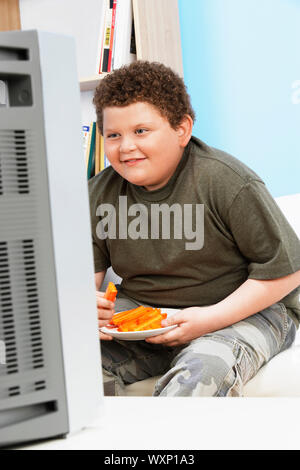 Übergewicht Kind essen Karotten Sticks Stockfoto