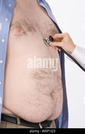Arzt-Hand mit Stethoskop auf übergewichtiger Mann Herz,, Mittelteil Stockfoto