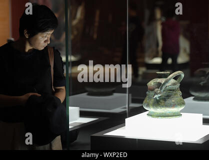(190917)-BEIJING, Sept. 17, 2019 (Xinhua) - ein Besucher eine Ausstellung auf einer Messe präsentiert Chinas Erfolge in kulturelles Relikt Retrieval im Nationalmuseum von China in Peking, der Hauptstadt von China, Sept. 17, 2019. Mehr als 600 wertvolle kulturelle Relikte sind zu sehen in der Ausstellung als Symbol für den schwierigen, aber fruchtbaren Weg des Landes kulturelles Relikt Retrieval in den letzten sieben Jahrzehnten. In vier Abschnitte unterteilt, die Ausstellung entfaltet 25 Geschichten wie die Reliquien und Artefakte nach Hause gebracht wurden. (Xinhua/Li Er) Stockfoto