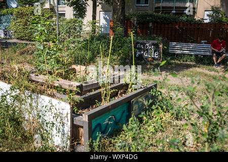 Ein Mann entspannt in einem bunten Straße Ecke öffentlichen Garten in Neukölln, Berlin, Deutschland. Stockfoto