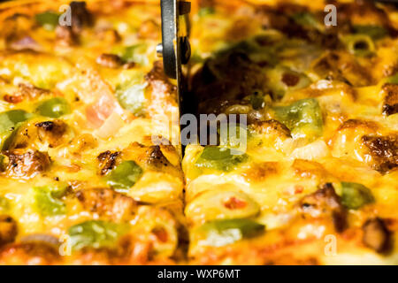 Pan Pizza schneiden Seite Nahaufnahme mit dunkelbraunem Holz Stockfoto