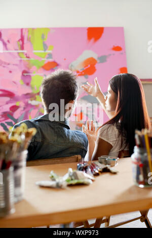 Paar diskutieren Malerei in Artist's Studio Stockfoto