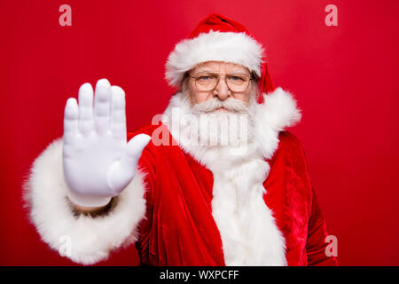 Portrait von stilvollen ernste zuversichtlich stirnrunzelnd Großvater Santa Gesicht in Handschuhe Brillen zeigen, STOP-Schild mit Öffnen Sie Palm Hand isoliert Stockfoto