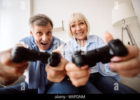 Reifes Paar Spielen von Videospielen zu begeistern Stockfoto