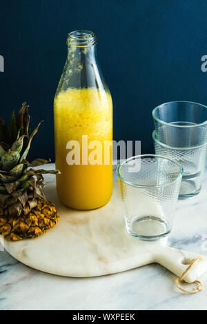 Frische Ananas Saft auf eine Tabelle in eine Flasche und Gläser. Stockfoto
