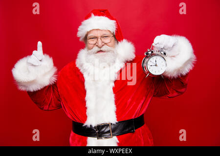 Holly Jolly x-mas! Die rechtzeitige freie Zeit Konzept. Stilvolle Reife im Alter von Saint Nicholas zeigen zeigen Zeigen finger Zeigefinger in Handschuhe halten Sie clock Stockfoto