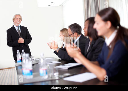 Business-Leute sitzen in einer Reihe an treffen und feiern Zielerreichung Stockfoto