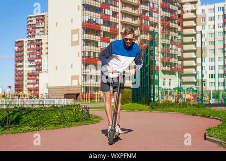 Frohen trendigen athletischer Kerl Antriebe eco Roller. Stockfoto