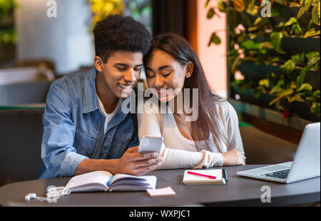 Glückliche Schüler, die die mobile Anwendung für das Studium Stockfoto