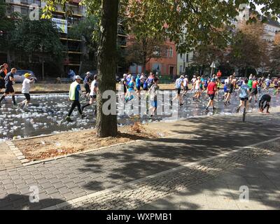 Berlin, Deutschland - 16. September 2018: Menschen in Berlin Marathon über Tonnen leere Plastikbecher läuft Stockfoto