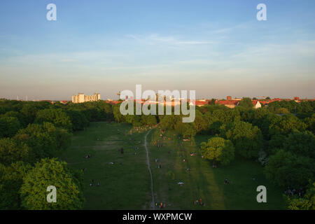 Luftbild von Berlin Park Hasenheide in Berlin-Kreuzberg auf einem Frühling Nachmittag mit Menschen entspannen und Spaß haben auf einer großen Wiese in der Sonne. Hinter dem Stockfoto