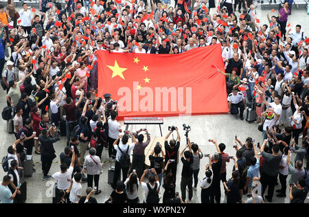 (190917) - SHANGHAI, Sept. 17, 2019 (Xinhua) - Passagiere und Mitarbeiter von Shanghai Hongqiao Bahnhof Teil in einem Flash Mob in der East China Shanghai, Sept. 17, 2019. Teilnehmer im Chor patriotische Lieder während der Flash Mob als Weise des 70. Jahrestages der Gründung der Volksrepublik China zu feiern. (Xinhua / Chen Fei) Stockfoto