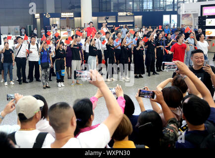 (190917) - SHANGHAI, Sept. 17, 2019 (Xinhua) - Passagiere und Mitarbeiter von Shanghai Hongqiao Bahnhof Teil in einem Flash Mob in der East China Shanghai, Sept. 17, 2019. Teilnehmer im Chor patriotische Lieder während der Flash Mob als Weise des 70. Jahrestages der Gründung der Volksrepublik China zu feiern. (Xinhua / Chen Fei) Stockfoto