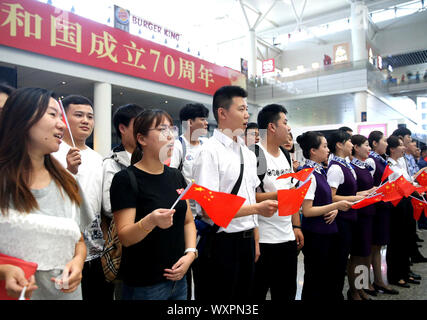 (190917) - SHANGHAI, Sept. 17, 2019 (Xinhua) - Passagiere und Mitarbeiter von Shanghai Hongqiao Bahnhof Teil in einem Flash Mob in der East China Shanghai, Sept. 17, 2019. Teilnehmer im Chor patriotische Lieder während der Flash Mob als Weise des 70. Jahrestages der Gründung der Volksrepublik China zu feiern. (Xinhua / Chen Fei) Stockfoto