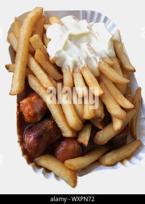 Currywurst & Pommes auf weißem Hintergrund: Berühmte deutsche Fast Food (Currywurst mit Pommes Frites und Curry Sauce) mit Ketchup und Mayonaise Stockfoto