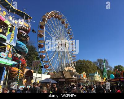 BERLIN - Juni 3, 2017: Riesenrad, Fun House und Erfrischung steht auf einem überfüllten Deutschen Kirmes bei schönem Wetter Stockfoto