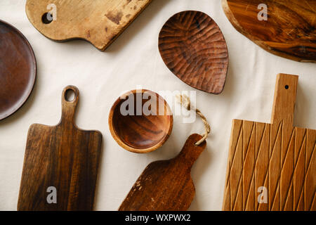 Verschiedene Holz- Geschirr. Schneidbretter, Teller und Schüssel auf Leinen Tischdecke