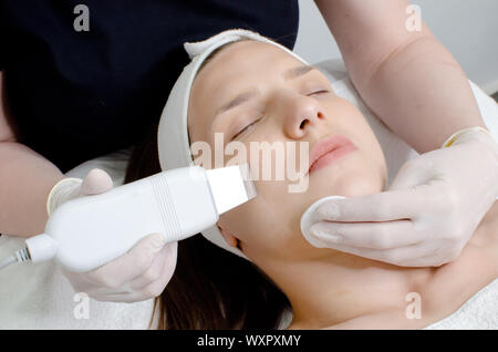 Schöne Frau mit Ultraschall gesichts Peeling verfahren Ultraschall Reinigung von Gesicht in Schönheitssalon. Moderne Ultraschall haut Ausrüstung Stockfoto