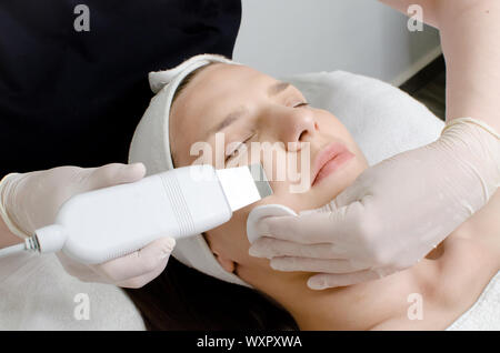 Schöne Frau mit Ultraschall gesichts Peeling verfahren Ultraschall Reinigung von Gesicht in Schönheitssalon. Moderne Ultraschall haut Ausrüstung Stockfoto