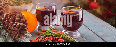 Glühwein, heiße Getränke mit Zitrusfrüchten, Apple und Gewürze in einem Drink Gläser auf dem Holztisch Stockfoto
