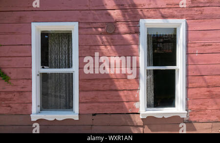 Rosa Holz- wand und zwei Fenster mit weißen Rahmen Stockfoto