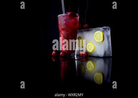 Alkoholische Getränke mit Erdbeere Obst, Limonade. Cocktails in Glas mit Ice Cube isoliert auf Schwarz. Bar und Restaurant, trinken. Party und Sommer va Stockfoto
