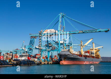 Eine Nahaufnahme Bild eines großen Containerschiff von Kranen mit blauer Himmel in den Hafen von Algeciras angedockt geladen wird, Spanien Stockfoto