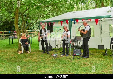 Die 60s 70s und Country Music band Dunne und verrostet, die in einem Dorf Straße Party auf Welby Village Green in der Nähe von Grantham in Lincolnshire Stockfoto