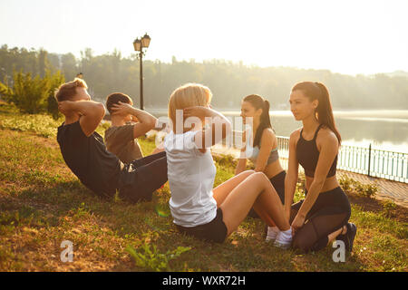 Eine Gruppe von Leuten, die Übungen im Park sitzen Stockfoto