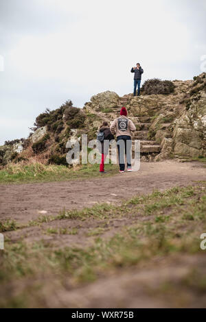 In der Nähe von Howth Dublin, Irland - 15. Februar 2019: Wanderer zu Fuß auf einem Wanderweg an der Steilküste entlang dem Meer in Howth, Irland Stockfoto