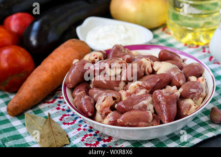 Rohes Huhn Herzen und Gemüse: Karotten, Auberginen, Tomaten und Zwiebeln, für ein leckeres und gesundes Abendessen, horizontale Ausrichtung Stockfoto