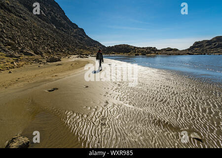 Ein Wanderer auf dem "Strand" von Loch Coir' a' Ghrunnda. Im Cuillin Mountains, Isle of Skye, Schottland, Großbritannien Stockfoto