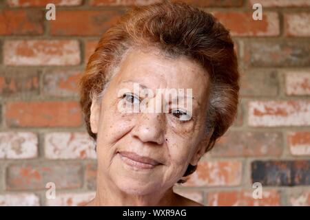 Porträt einer älteren Frau über das Leben mit einem glücklichen Grinsen Stockfoto