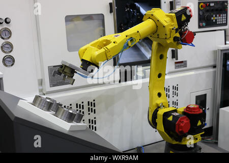 Automatisierte CNC-Maschine laden mit Roboterarm. Selektive konzentrieren. Stockfoto