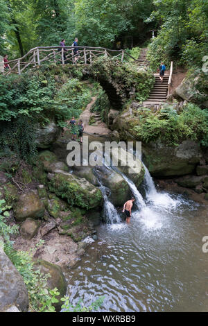 Heringer Millen, Müllerthal/Luxemburg, 11. August 2019: touristischen Besuch und Schwimmen am idyllischen Wasserfall Schiessentuempel im Müllerthal Stockfoto