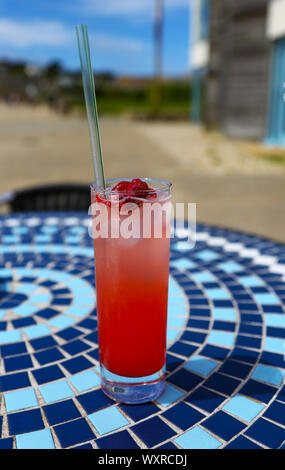 Eine lange, kalte Getränk aus Himbeeren und Soda Wasser oder Limonade in ein Glas mit Strohhalm auf einem Tisch im Sommer Stockfoto