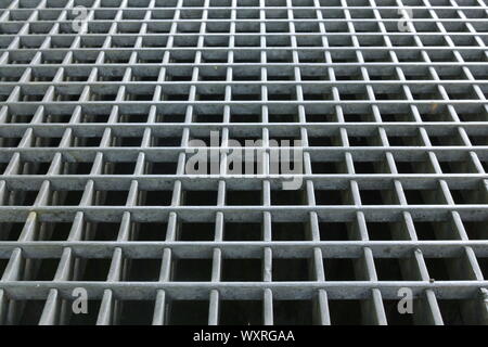 Schräge auf einem Raster über eine Bohrung, die als Hintergrund verwendet werden kann. Stockfoto