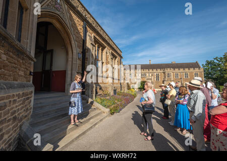 Besucher außerhalb der Halle auf einer geführten Tour von Charterhouse School, eine historische Internat in Surrey, England, UK. Stockfoto