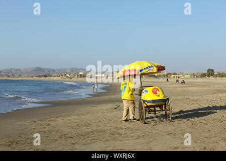 LOS ORGANOS, PERU - 30. AUGUST 2013: Nicht identifizierte Person verkaufen Eis in einem Warenkorb am Sandstrand am 30. August 2013 in Los Organos, Peru. Los O Stockfoto