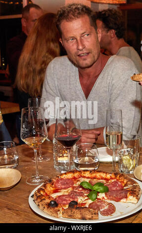 Hamburg, Deutschland. 17 Sep, 2019. Til Schweiger, Schauspieler, sitzt vor einem Teller mit einer Pizza während der Präsentation der neuen Konzept' Henry Pizza" in seinem Restaurant "Barefood Deli' mag. Quelle: Georg Wendt/dpa/Alamy leben Nachrichten Stockfoto