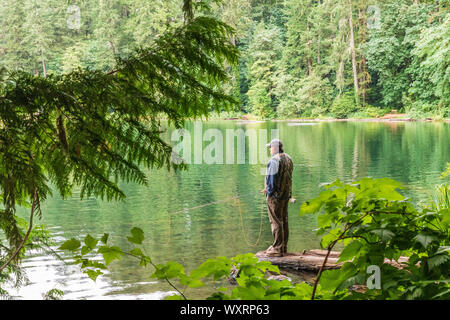 USA, Washington State, Battle Ground Lake State Park. August 18, 2019. Ein Fischer am See. Stockfoto