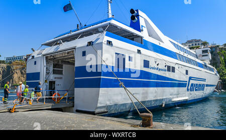 SORRENTO, ITALIEN - AUGUST 2019: Schnelles Auto- und Passagierfähre in Sorrent angedockt. Eine Familie ist zu Fuß auf das Schiff. Stockfoto