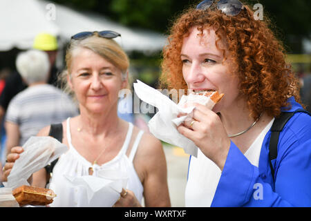 Moline, Iowa, USA. 15 Sep, 2019. Magali Kelfkens, Generalkonsulat des Königreichs Belgien, rechts, nimmt einen Bissen von ihrem während der der 7. jährlichen Belgischen Fest am Stephens Park Sonntag, 15. September 2019, in Moline. Credit: Meg Mclaughlin/Mmclaughlin@Qconl/Viererkabel - Zeiten/ZUMA Draht/Alamy leben Nachrichten Stockfoto