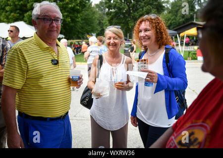 Moline, Iowa, USA. 15 Sep, 2019. Patrick Van Nevel, ehrenmitglieder Moline das Konsulat zu Belgien, Anna Hajdu, Generalkonsulat des Königreichs Belgien, und Magali Kelfkens, Generalkonsulat des Königreichs Belgien, Kauf Waffeln während der 7. jährlichen Belgischen Fest am Stephens Park Sonntag, 15. September 2019, in Moline. Credit: Meg Mclaughlin/Mmclaughlin@Qconl/Viererkabel - Zeiten/ZUMA Draht/Alamy leben Nachrichten Stockfoto
