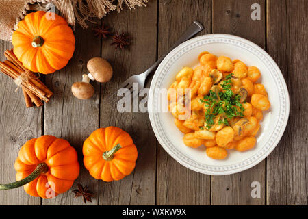 Gnocchi mit einem Kürbis, mushroom cream Sauce. Herbst Mahlzeit. Oben Ansicht Tabelle Szene auf einem Holz Hintergrund. Stockfoto