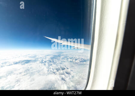 Blick aus einem Boeing 787-Fenster beim Flug über schneebedeckte Berge. Stockfoto